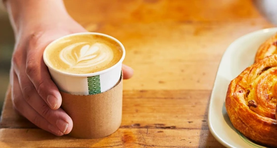 Close up of man's hand serving a coffee at a coffee shop