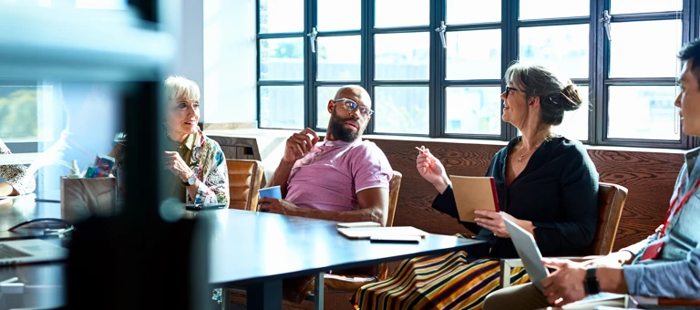 People sitting around a conference room table having a business meeting.