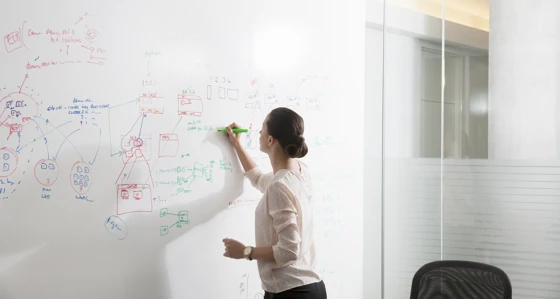 A woman writing on a whiteboard