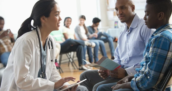 Doctor using digital tablet with patients