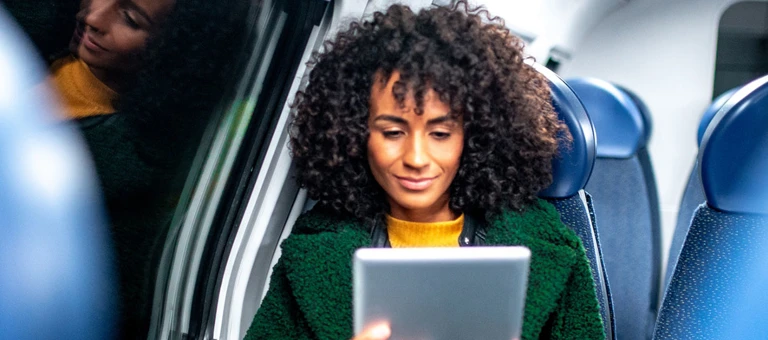 A woman sitting on a train looking at her phone