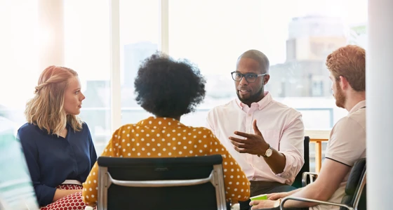 Four people having a discussion in an office