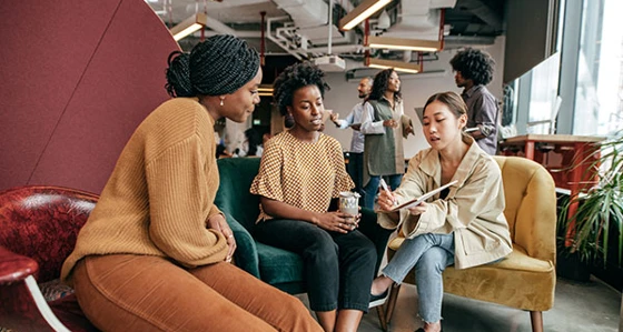 Three people having a discussion in the office
