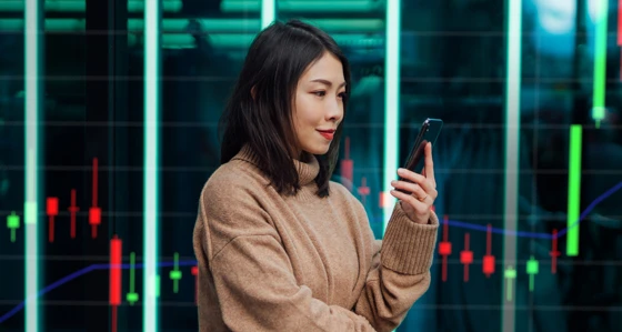 Young woman using her phone in front of backdrop
