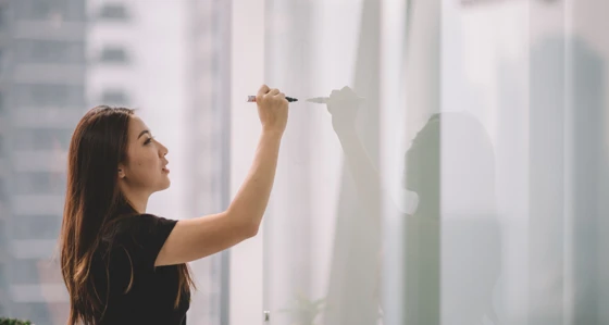 Young woman writing on whiteboard