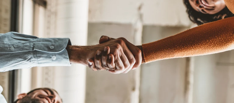 A view from below of two people shaking hands