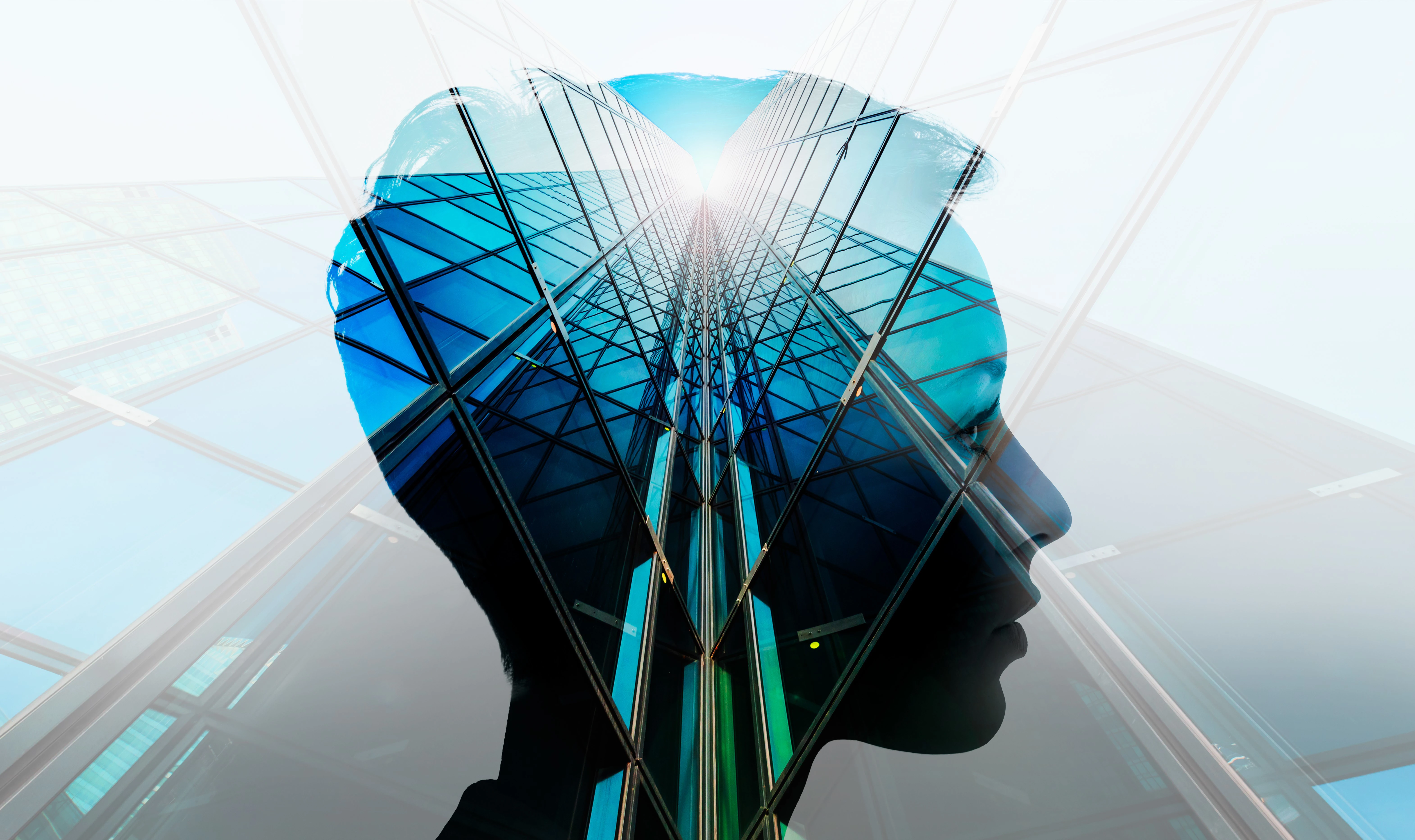 A human head superimposed over a upwards view of a skyscraper