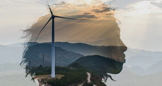 A woman's head superimposed over a hillside with a wind turbine