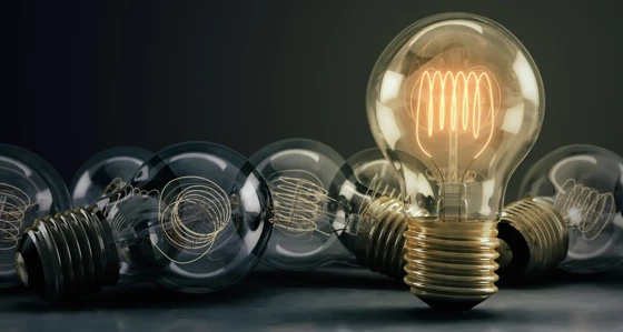 A collection of lightbulbs with one illuminated