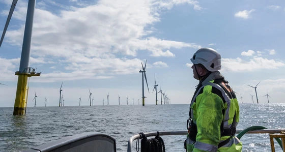 An engineer in a boat approaching an offshore wind farm