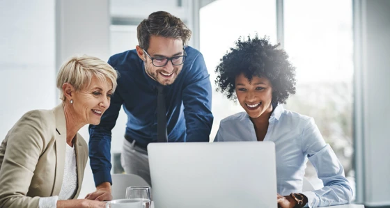 Three people working together on a laptop