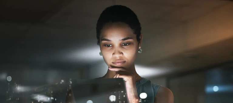 Woman looking at data on a tablet with overlay of city skyline